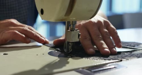Die fachkundige Hand eines jungen Schneiders näht das Tuch und kann dann Zuschüsse für maßgeschneiderte Kleidung gewähren f