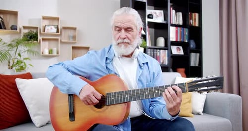 Senior Man Playing Guitar at Home