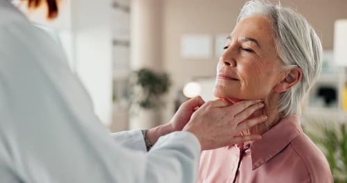 Doctor Examines Senior Woman Patient in Office