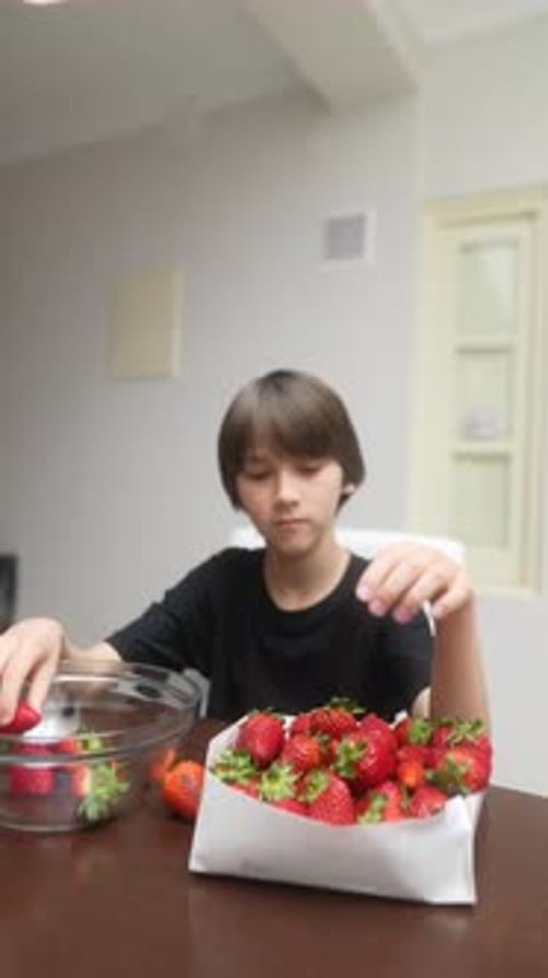 Un enfant joyeux appréciant pleinement la cueillette de fraises dans une cuisine lumineuse et joyeuse