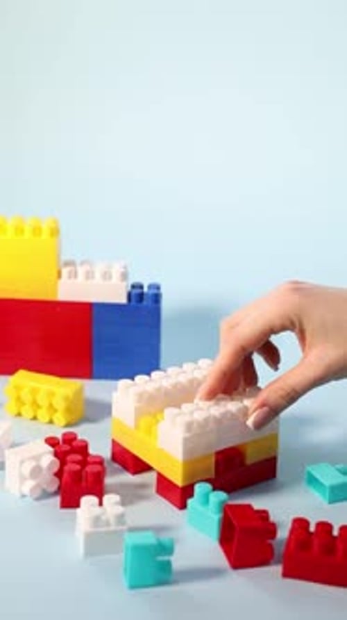 Mujer con bloques de construcción coloridos sobre fondo claro, primer plano