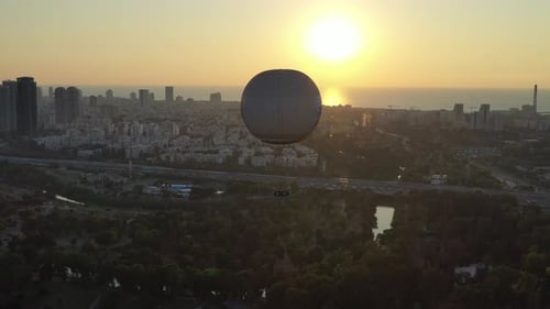Aerial Shot Of Hot Air Balloon Descending Over Yarkon Park Against Sky In City