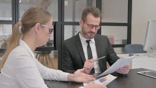 Business People Discussing Business Report in Office
