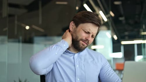 Man Experiences Neck Pain in Modern Office Setting