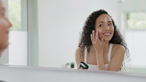 Woman Applying Moisturizer in Bright Bathroom