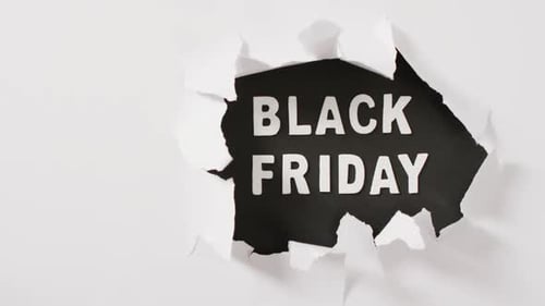 Ripped white paper over black friday text in white on black background