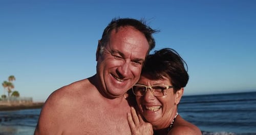 Smiling couple embracing on sunny beach vacation