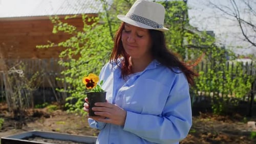 Woman Holds Flower Pot in Sunny Garden