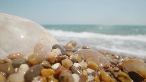 Steine am Meeresstrand sind mit einer Welle bedeckt. Supermakro, Unterwasserkamera.