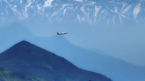 Drone shot of plane in flight ascending, with the snowy mountain range, Cerro El Lead, Cerro Colina