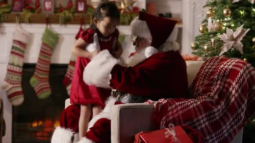 Girl Sits on Santa's Lap in Cozy Home