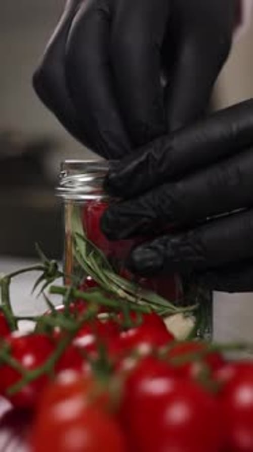 The chef preserves vegetables in the kitchen. Close-up