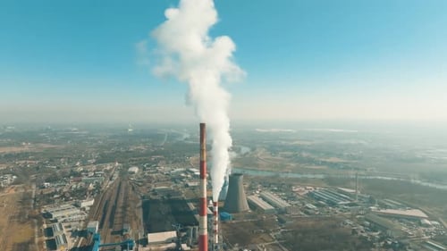 A coal power plant releases large plumes of smoke into the sky