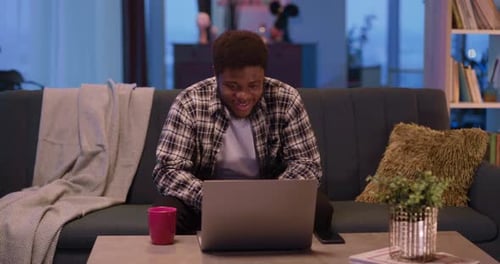 Afroamerican Handsome College Student Young Man Videochatting on Social Media Using Laptop Talking