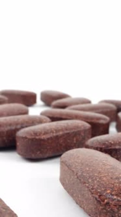 Close Up of Brown Pharmaceutical Pills on White