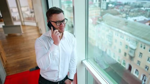Man Talking on Phone in Bright Office