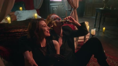 Vampire Man and Woman Smiling Intimately as They Sitting on Floor in Bedroom