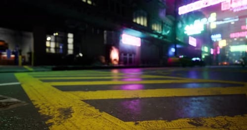 Neon Lights Illuminate a Wet Street at Night in an Urban Setting