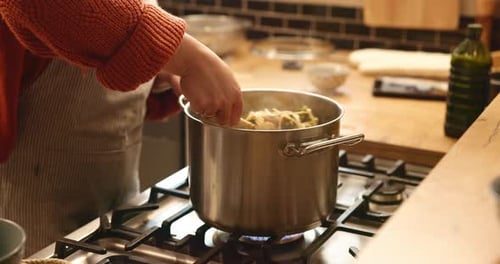Cooking at Stove with Orange Sweater