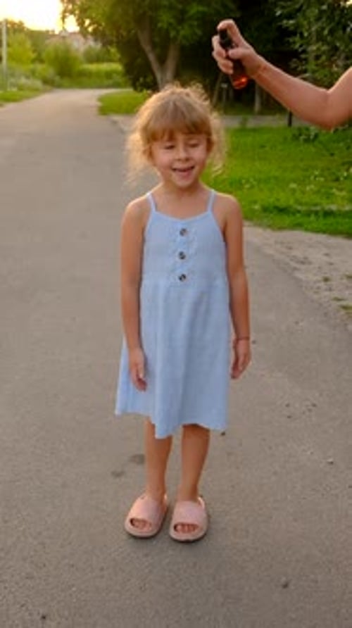 Little Girl Being Sprayed With Bug Repellent Outside