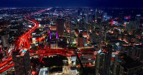 Huge lively interchange and highways colored red at night. Drone footage over the stunning