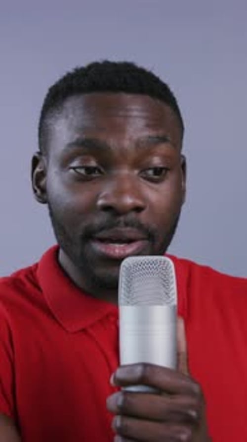 Attractive AfroAmerican Man Uses Microphone and Preaches on Grey Background Male Portrait Close Up