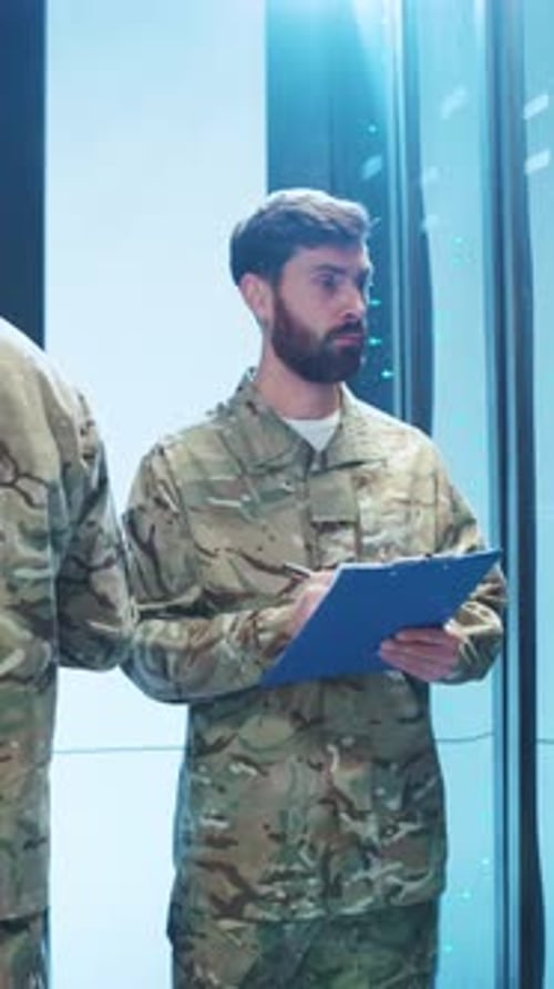 Man in Camouflage Uniform Inspecting Server Rack