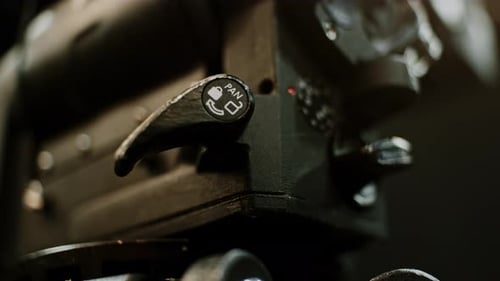 The pan lock of a professional high-end cinema tripod fluid head being adjusted, first locking then