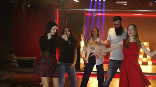 Enthusiastic Young Adults Dancing Together in Nightclub