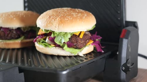 Delicious Burgers Cooking on a Grill Press