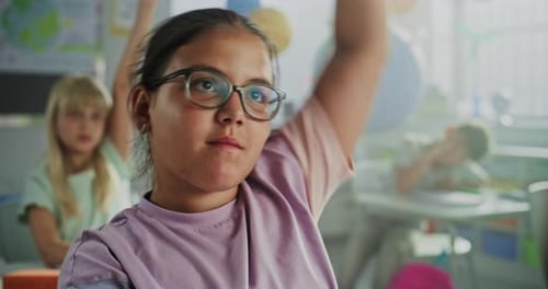 Close Up of Elementary School Girl Raising Hand and Answering Teacher's Question During Geography
