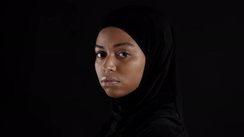 Halbprofilporträt einer jungen depressiven muslimischen Afroamerikanerin im Hijab, die ihr Gesicht dreht und