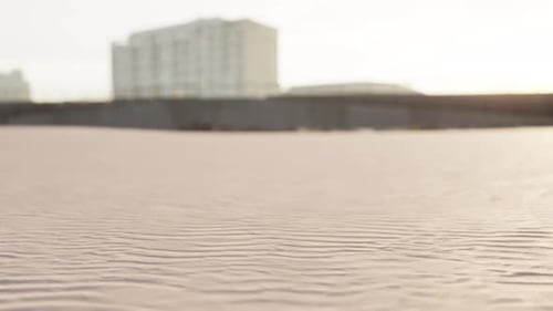 Early Morning Empty Beach Against City Buildings