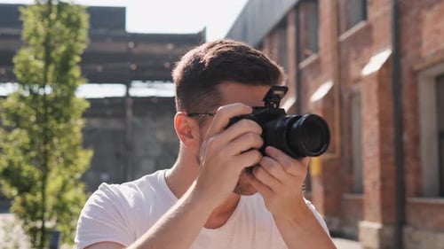 Man Taking Photos With Digital Camera in City