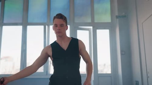 Man Twirls Belt in Sleek Fluid Dance Pose in Loft Studio with Smoke Haze