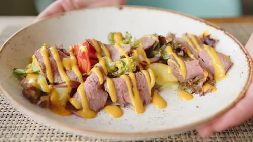 Plate with Meat and Salad Being Placed on Table