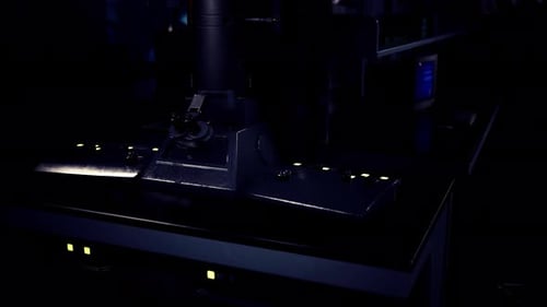 Dark Laboratory with Glowing Microscope and Modern Equipment