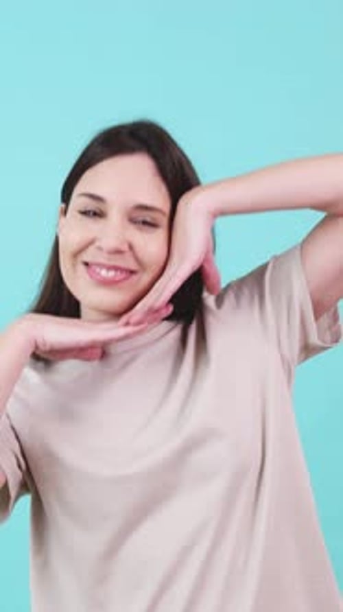 Jeune femme faisant des grimaces sur fond turquoise
