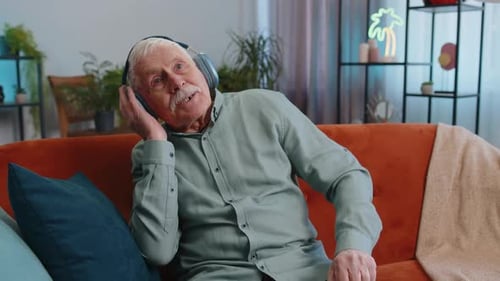 Energetic Senior Man Listening to Music on Couch