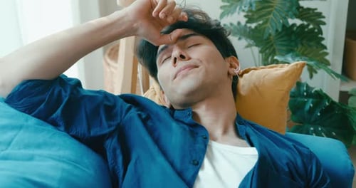 Man Relaxes with Laptop on a Blue Couch