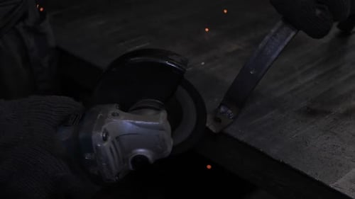 A man is working with a circular saw. Sparks fly from hot metal. Slow motion close up
