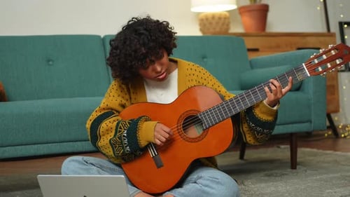 Young Adult Plays Guitar at Home