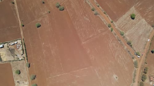 Top down Aerial of dry farmlands with green trees in rural Kenya