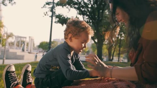 Brother and Older Sister Play in the Park in the Spring at Sunset Happy Family Slow Motion