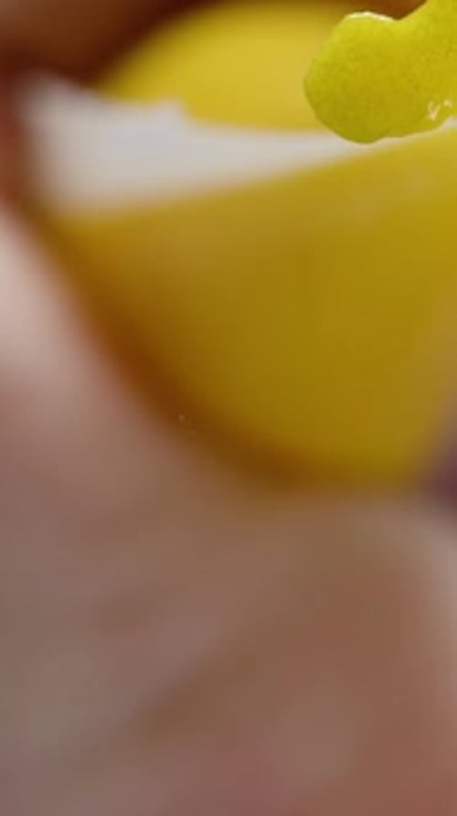 Vertical video. Using a pastry bag, applying yellow icing on glass. Close-up, view from below.