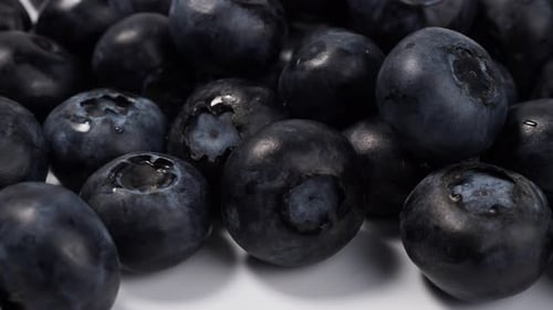 Ripe blueberries on a light background.