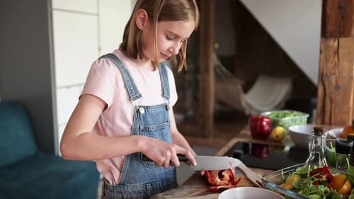Child Preparing Salad in the Kitchen at Home