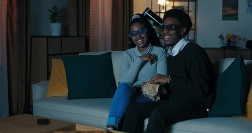 Couple Enjoying 3D Movie with Popcorn at Home