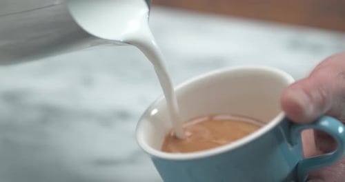 Close Up of Barista Making Latte Art by Pourring Milk In