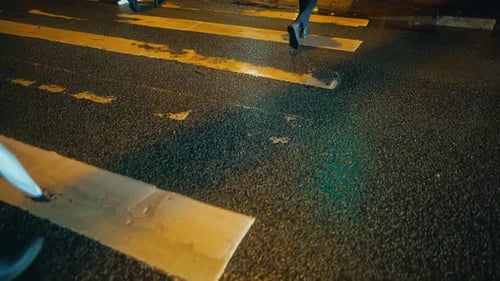 Pessoa atravessando a faixa de pedestres na superfície da estrada de asfalto à noite